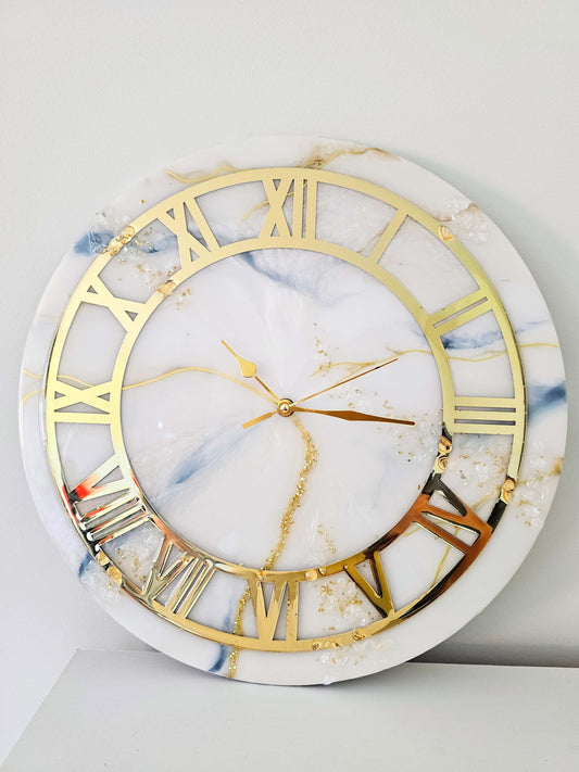 White and gold marble effect hand-crafted resin wall clock, with round golden ringThis hand-crafted resin wall clock features a beautiful marble effect that will add a touch of elegance to your living space and leave a lasting impression on all your guest