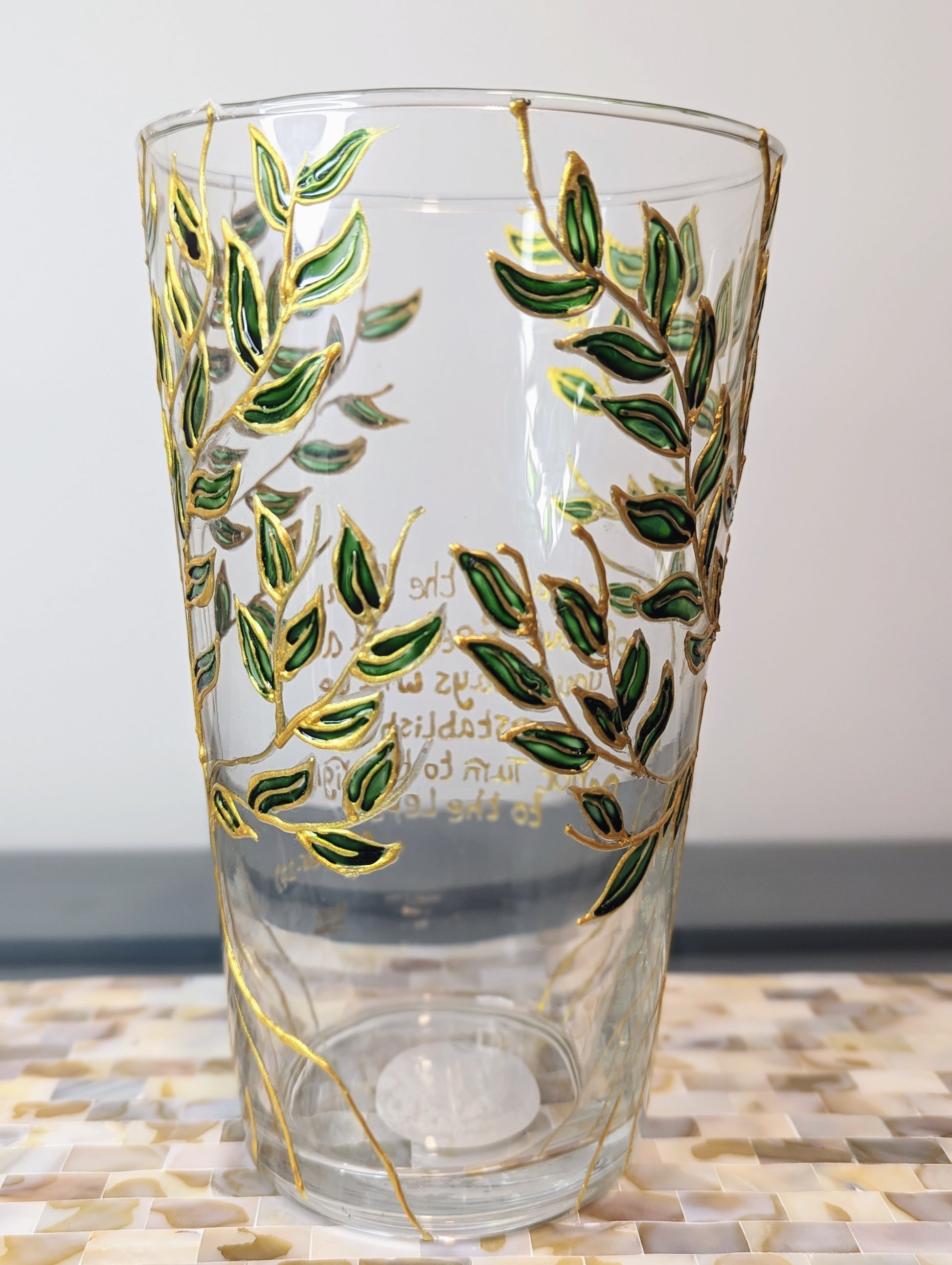 Personalised hand-painted glass vase with green and gold leavesThis hand-painted glass vase features a unique green and gold leaves and tree design, making it a 100% original piece of art. Each vase is hand-painted, ensuring no two are alike. Make it even