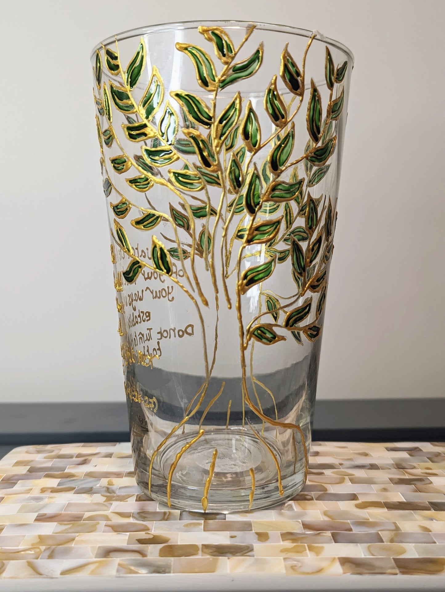 Personalised hand-painted glass vase with green and gold leavesThis hand-painted glass vase features a unique green and gold leaves and tree design, making it a 100% original piece of art. Each vase is hand-painted, ensuring no two are alike. Make it even
